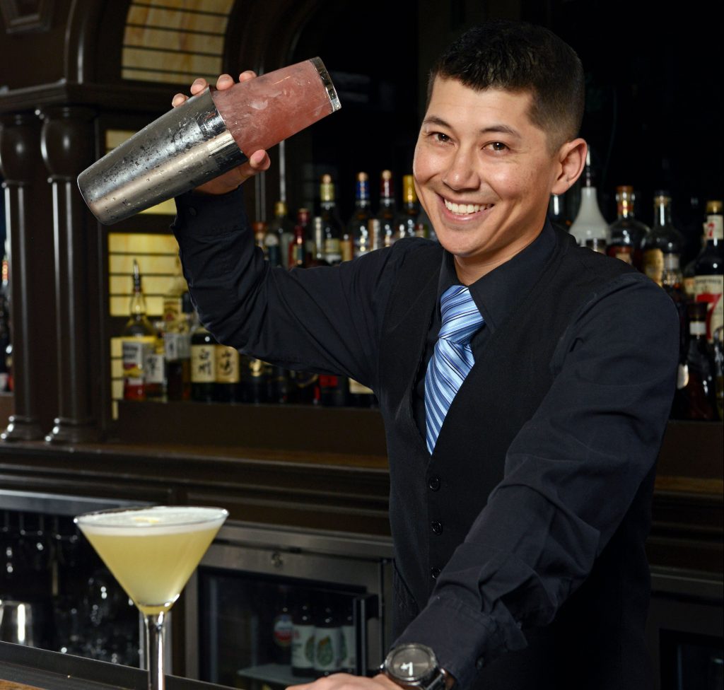 Yoshi Hiraoka prepares a drink behind the bar.