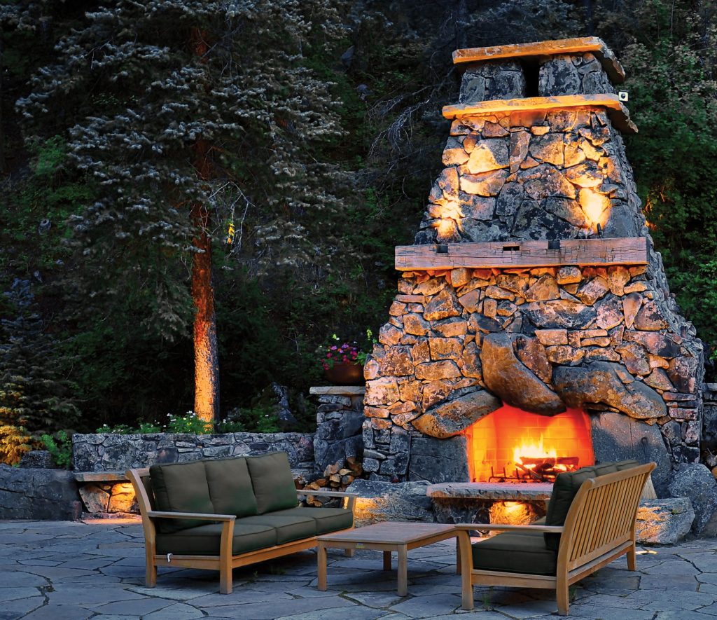 A nighttime view of a beautiful outdoor fire space designed by Designscapes Colorado.